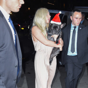 Lady Gaga et son fiancé Taylor Kinney à une soirée à New York avec un chien déguisé en père noël le 11 décembre 2015.