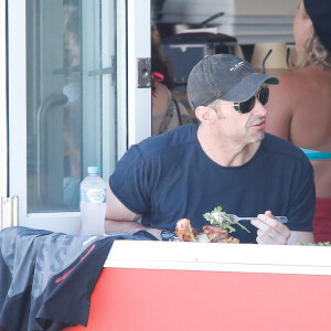 Exclusif - Hugh Jackman déjeune avec un ami sur la plage de Bondi Beach dans un restaurant spécialisé dans le poulet à Sydney en Australie le 1er décembre 2015.