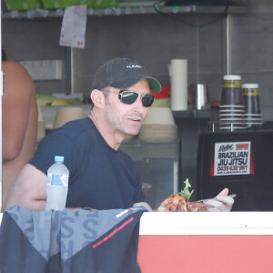 Exclusif - Hugh Jackman déjeune avec un ami sur la plage de Bondi Beach dans un restaurant spécialisé dans le poulet à Sydney en Australie le 1er décembre 2015.