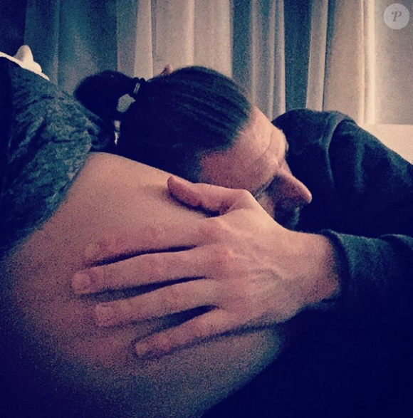 Aurélie Van Daelen au bord de l'accouchement. Son compagnon pose délicatement la tête sur son ventre arrondi. Décembre 2015.