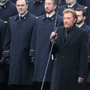 Johnny Hallyday, accompagné par Yodelice et Yarol Poupaud, chante "Un dimanche de janvier" en hommage aux victimes des attentats de janvier et novembre. Place de la République à Paris, le 10 janvier 2016.