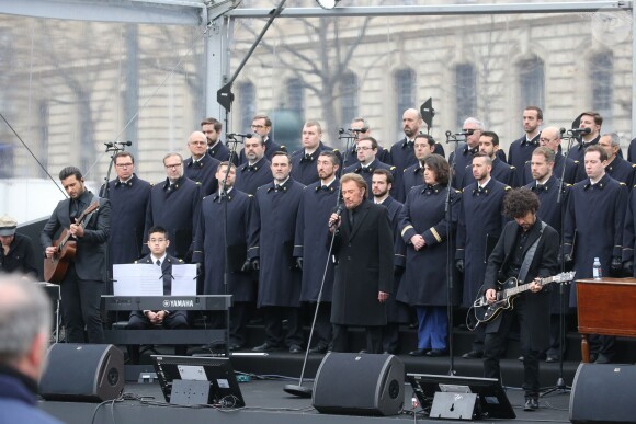 Johnny Hallyday, accompagné par Yodelice et Yarol Poupaud, chante "Un dimanche de janvier" en hommage aux victimes des attentats de janvier et novembre. Place de la République à Paris, le 10 janvier 2016.