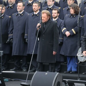 Johnny Hallyday, accompagné par Yodelice et Yarol Poupaud, chante "Un dimanche de janvier" en hommage aux victimes des attentats de janvier et novembre. Place de la République à Paris, le 10 janvier 2016.