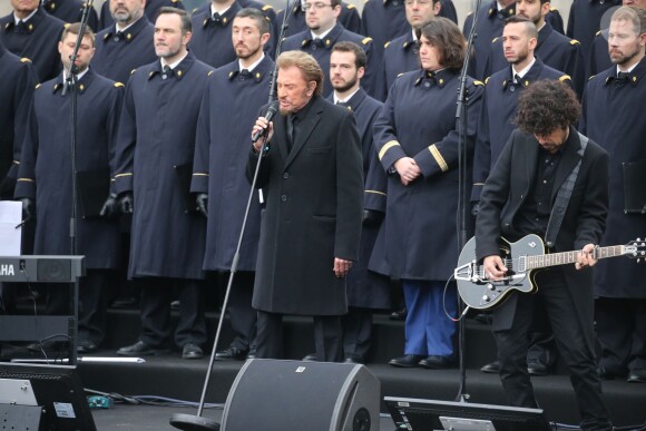 Johnny Hallyday, accompagné par Yodelice et Yarol Poupaud, chante "Un dimanche de janvier" en hommage aux victimes des attentats de janvier et novembre. Place de la République à Paris, le 10 janvier 2016.