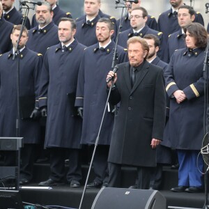 Johnny Hallyday, accompagné par Yodelice et Yarol Poupaud, chante "Un dimanche de janvier" en hommage aux victimes des attentats de janvier et novembre. Place de la République à Paris, le 10 janvier 2016.