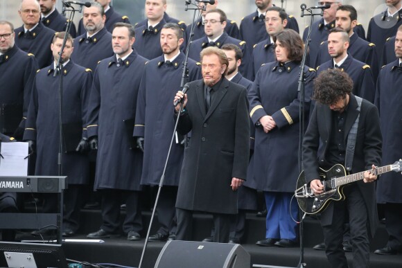 Johnny Hallyday, accompagné par Yodelice et Yarol Poupaud, chante "Un dimanche de janvier" en hommage aux victimes des attentats de janvier et novembre. Place de la République à Paris, le 10 janvier 2016.