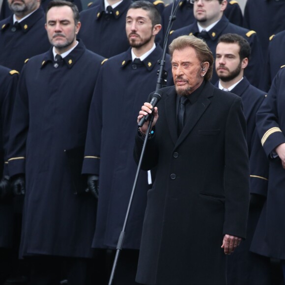 Johnny Hallyday, accompagné par Yodelice et Yarol Poupaud, chante "Un dimanche de janvier" en hommage aux victimes des attentats de janvier et novembre. Place de la République à Paris, le 10 janvier 2016.