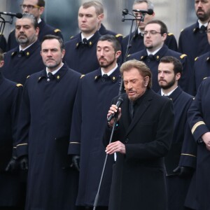 Johnny Hallyday, accompagné par Yodelice et Yarol Poupaud, chante "Un dimanche de janvier" en hommage aux victimes des attentats de janvier et novembre. Place de la République à Paris, le 10 janvier 2016.