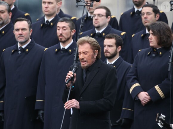 Johnny Hallyday, accompagné par Yodelice et Yarol Poupaud, chante "Un dimanche de janvier" en hommage aux victimes des attentats de janvier et novembre. Place de la République à Paris, le 10 janvier 2016.