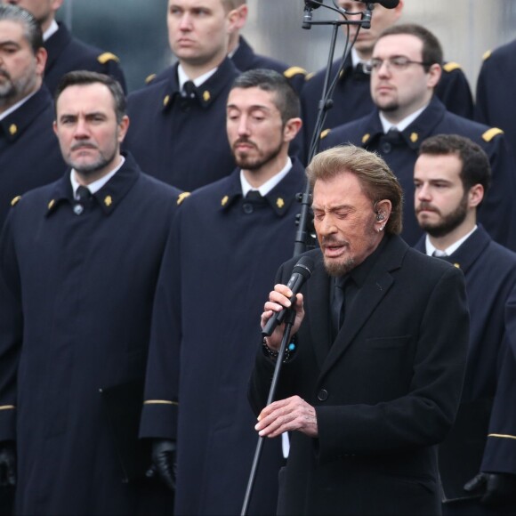 Johnny Hallyday, accompagné par Yodelice et Yarol Poupaud, chante "Un dimanche de janvier" en hommage aux victimes des attentats de janvier et novembre. Place de la République à Paris, le 10 janvier 2016.