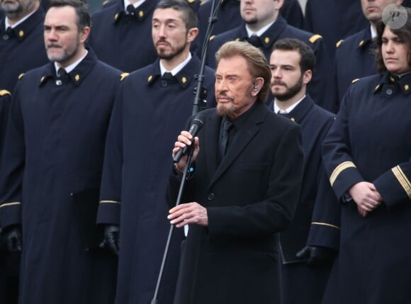 Johnny Hallyday, accompagné par Yodelice et Yarol Poupaud, chante "Un dimanche de janvier" en hommage aux victimes des attentats de janvier et novembre. Place de la République à Paris, le 10 janvier 2016.