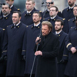 Johnny Hallyday, accompagné par Yodelice et Yarol Poupaud, chante "Un dimanche de janvier" en hommage aux victimes des attentats de janvier et novembre. Place de la République à Paris, le 10 janvier 2016.