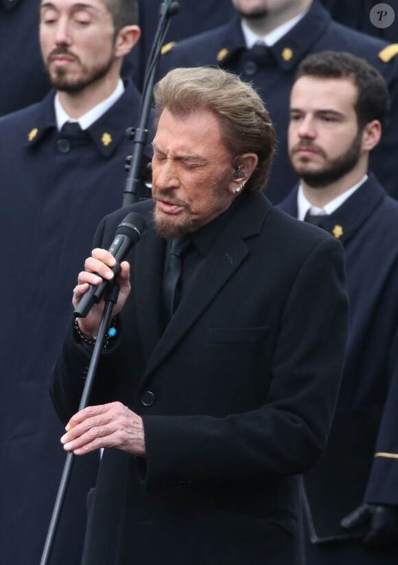 Johnny Hallyday, accompagné par Yodelice et Yarol Poupaud, chante "Un dimanche de janvier" en hommage aux victimes des attentats de janvier et novembre. Place de la République à Paris, le 10 janvier 2016.