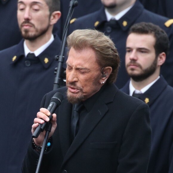 Johnny Hallyday, accompagné par Yodelice et Yarol Poupaud, chante "Un dimanche de janvier" en hommage aux victimes des attentats de janvier et novembre. Place de la République à Paris, le 10 janvier 2016.