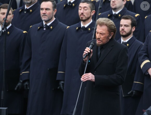 Johnny Hallyday, accompagné par Yodelice et Yarol Poupaud, chante "Un dimanche de janvier" en hommage aux victimes des attentats de janvier et novembre. Place de la République à Paris, le 10 janvier 2016.