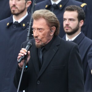 Johnny Hallyday, accompagné par Yodelice et Yarol Poupaud, chante "Un dimanche de janvier" en hommage aux victimes des attentats de janvier et novembre. Place de la République à Paris, le 10 janvier 2016.