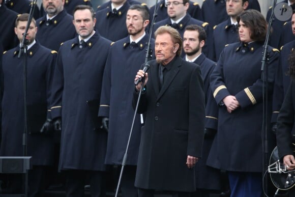 Johnny Hallyday, accompagné par Yodelice et Yarol Poupaud, chante "Un dimanche de janvier" en hommage aux victimes des attentats de janvier et novembre. Place de la République à Paris, le 10 janvier 2016.