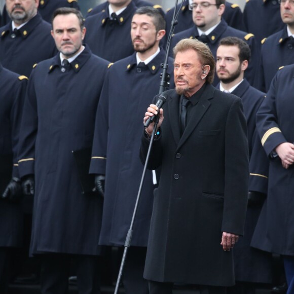 Johnny Hallyday, accompagné par Yodelice et Yarol Poupaud, chante "Un dimanche de janvier" en hommage aux victimes des attentats de janvier et novembre. Place de la République à Paris, le 10 janvier 2016.