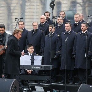 Johnny Hallyday, accompagné par Yodelice et Yarol Poupaud, chante "Un dimanche de janvier" en hommage aux victimes des attentats de janvier et novembre. Place de la République à Paris, le 10 janvier 2016.