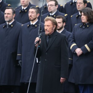 Johnny Hallyday, accompagné par Yodelice et Yarol Poupaud, chante "Un dimanche de janvier" en hommage aux victimes des attentats de janvier et novembre. Place de la République à Paris, le 10 janvier 2016.