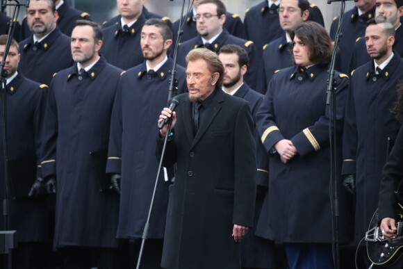 Johnny Hallyday, accompagné par Yodelice et Yarol Poupaud, chante "Un dimanche de janvier" en hommage aux victimes des attentats de janvier et novembre. Place de la République à Paris, le 10 janvier 2016.