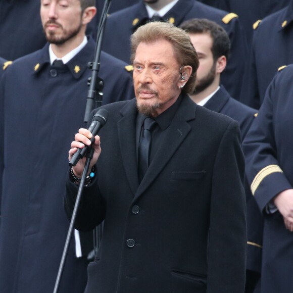 Johnny Hallyday, accompagné par Yodelice et Yarol Poupaud, chante "Un dimanche de janvier" en hommage aux victimes des attentats de janvier et novembre. Place de la République à Paris, le 10 janvier 2016.