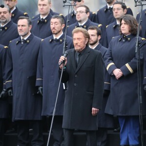 Johnny Hallyday, accompagné par Yodelice et Yarol Poupaud, chante "Un dimanche de janvier" en hommage aux victimes des attentats de janvier et novembre. Place de la République à Paris, le 10 janvier 2016.