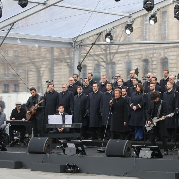 Johnny Hallyday, accompagné par Yodelice et Yarol Poupaud, chante "Un dimanche de janvier" en hommage aux victimes des attentats de janvier et novembre. Place de la République à Paris, le 10 janvier 2016.