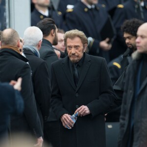 Johnny Hallyday, accompagné par Yodelice et Yarol Poupaud, chante "Un dimanche de janvier" en hommage aux victimes des attentats de janvier et novembre. Place de la République à Paris, le 10 janvier 2016.