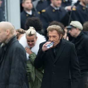 Johnny Hallyday, accompagné par Yodelice et Yarol Poupaud, chante "Un dimanche de janvier" en hommage aux victimes des attentats de janvier et novembre. Place de la République à Paris, le 10 janvier 2016.