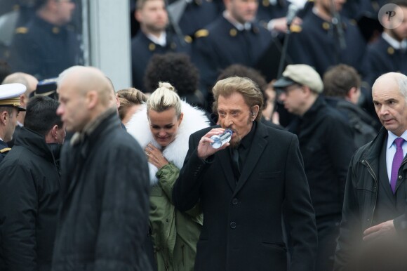 Johnny Hallyday, accompagné par Yodelice et Yarol Poupaud, chante "Un dimanche de janvier" en hommage aux victimes des attentats de janvier et novembre. Place de la République à Paris, le 10 janvier 2016.