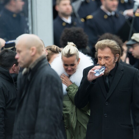 Johnny Hallyday, accompagné par Yodelice et Yarol Poupaud, chante "Un dimanche de janvier" en hommage aux victimes des attentats de janvier et novembre. Place de la République à Paris, le 10 janvier 2016.