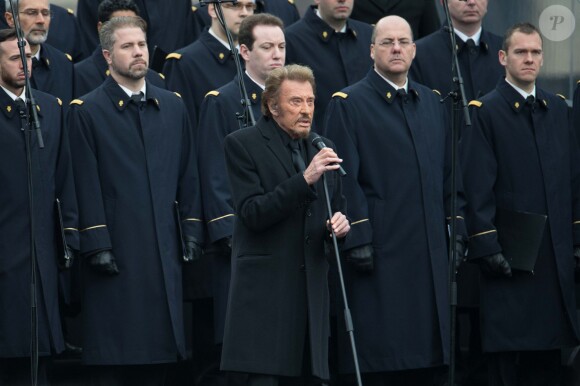 Johnny Hallyday, accompagné par Yodelice et Yarol Poupaud, chante "Un dimanche de janvier" en hommage aux victimes des attentats de janvier et novembre. Place de la République à Paris, le 10 janvier 2016.