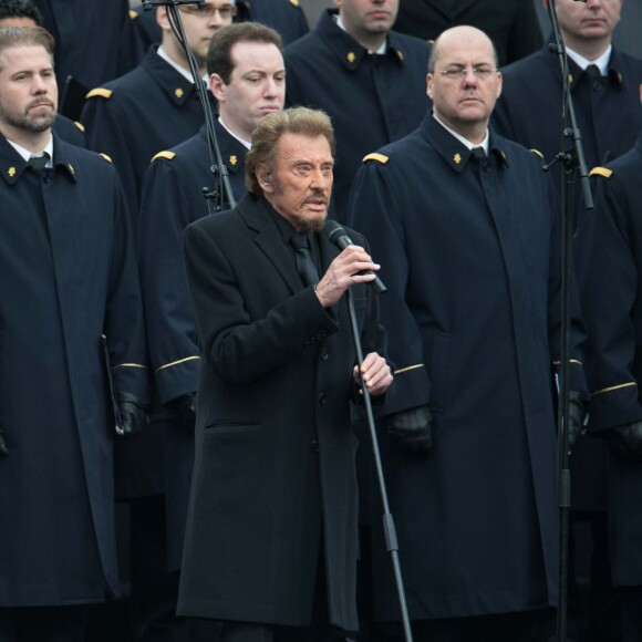 Johnny Hallyday, accompagné par Yodelice et Yarol Poupaud, chante "Un dimanche de janvier" en hommage aux victimes des attentats de janvier et novembre. Place de la République à Paris, le 10 janvier 2016.