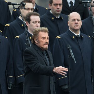 Johnny Hallyday, accompagné par Yodelice et Yarol Poupaud, chante "Un dimanche de janvier" en hommage aux victimes des attentats de janvier et novembre. Place de la République à Paris, le 10 janvier 2016.