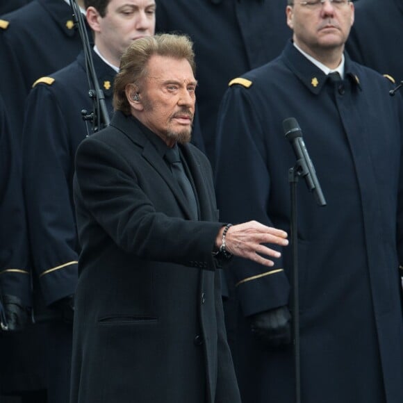 Johnny Hallyday, accompagné par Yodelice et Yarol Poupaud, chante "Un dimanche de janvier" en hommage aux victimes des attentats de janvier et novembre. Place de la République à Paris, le 10 janvier 2016.