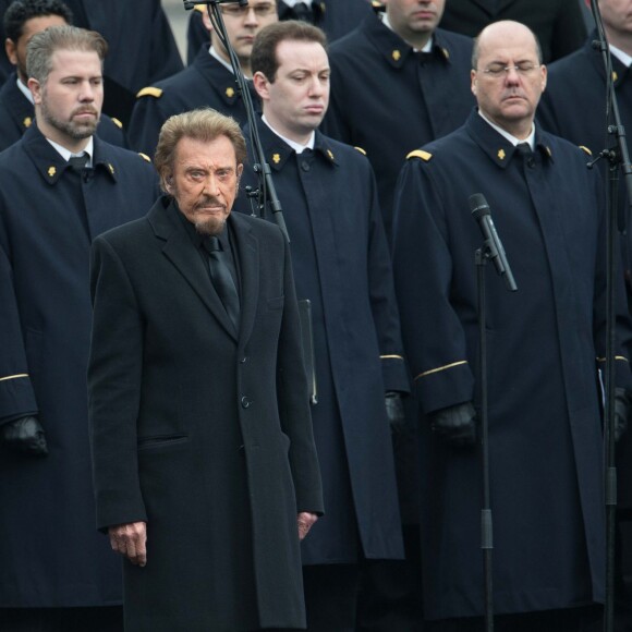 Johnny Hallyday, accompagné par Yodelice et Yarol Poupaud, chante "Un dimanche de janvier" en hommage aux victimes des attentats de janvier et novembre. Place de la République à Paris, le 10 janvier 2016.