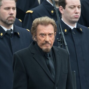 Johnny Hallyday, accompagné par Yodelice et Yarol Poupaud, chante "Un dimanche de janvier" en hommage aux victimes des attentats de janvier et novembre. Place de la République à Paris, le 10 janvier 2016.