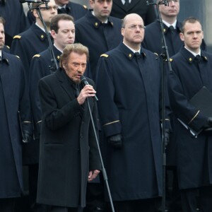 Johnny Hallyday, accompagné par Yodelice et Yarol Poupaud, chante "Un dimanche de janvier" en hommage aux victimes des attentats de janvier et novembre. Place de la République à Paris, le 10 janvier 2016.