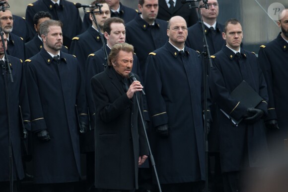 Johnny Hallyday, accompagné par Yodelice et Yarol Poupaud, chante "Un dimanche de janvier" en hommage aux victimes des attentats de janvier et novembre. Place de la République à Paris, le 10 janvier 2016.
