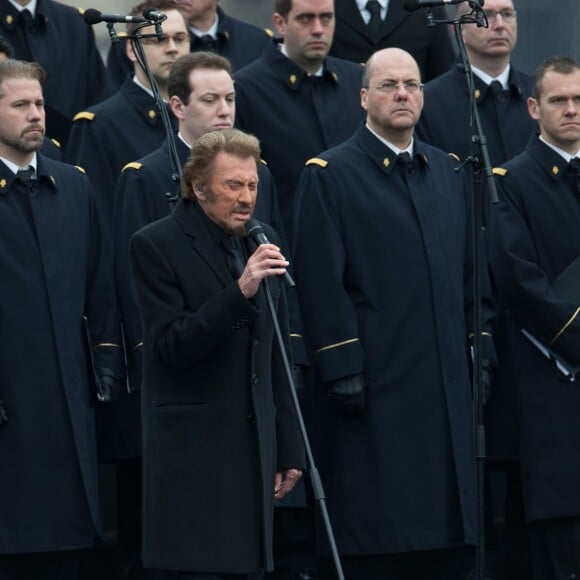 Johnny Hallyday, accompagné par Yodelice et Yarol Poupaud, chante "Un dimanche de janvier" en hommage aux victimes des attentats de janvier et novembre. Place de la République à Paris, le 10 janvier 2016.