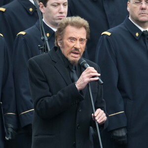 Johnny Hallyday, accompagné par Yodelice et Yarol Poupaud, chante "Un dimanche de janvier" en hommage aux victimes des attentats de janvier et novembre. Place de la République à Paris, le 10 janvier 2016.