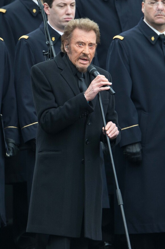 Johnny Hallyday, accompagné par Yodelice et Yarol Poupaud, chante "Un dimanche de janvier" en hommage aux victimes des attentats de janvier et novembre. Place de la République à Paris, le 10 janvier 2016.