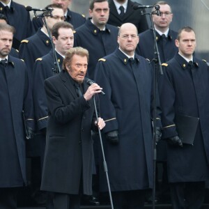 Johnny Hallyday, accompagné par Yodelice et Yarol Poupaud, chante "Un dimanche de janvier" en hommage aux victimes des attentats de janvier et novembre. Place de la République à Paris, le 10 janvier 2016.