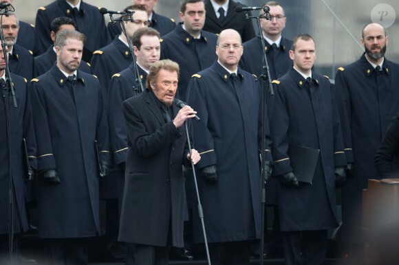 Johnny Hallyday, accompagné par Yodelice et Yarol Poupaud, chante "Un dimanche de janvier" en hommage aux victimes des attentats de janvier et novembre. Place de la République à Paris, le 10 janvier 2016.