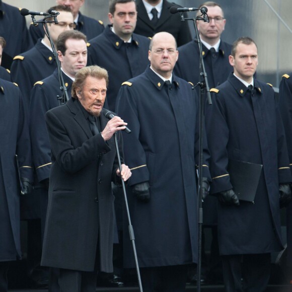 Johnny Hallyday, accompagné par Yodelice et Yarol Poupaud, chante "Un dimanche de janvier" en hommage aux victimes des attentats de janvier et novembre. Place de la République à Paris, le 10 janvier 2016.