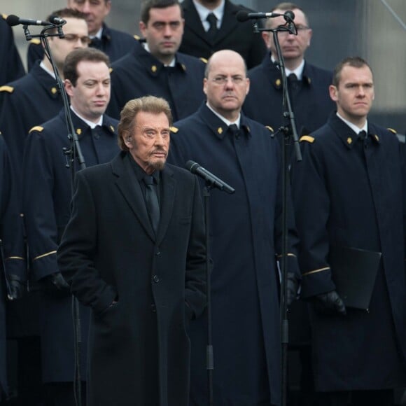 Johnny Hallyday, accompagné par Yodelice et Yarol Poupaud, chante "Un dimanche de janvier" en hommage aux victimes des attentats de janvier et novembre. Place de la République à Paris, le 10 janvier 2016.