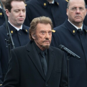 Johnny Hallyday, accompagné par Yodelice et Yarol Poupaud, chante "Un dimanche de janvier" en hommage aux victimes des attentats de janvier et novembre. Place de la République à Paris, le 10 janvier 2016.