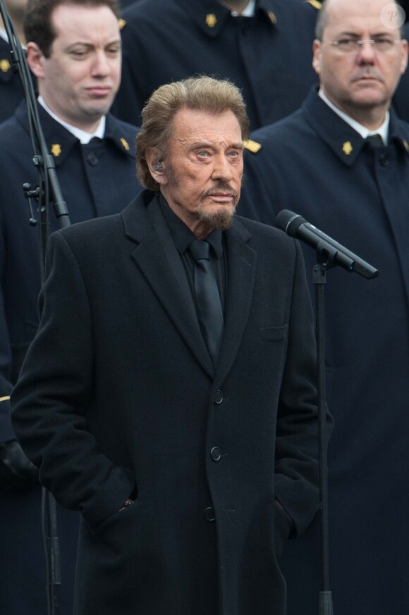 Johnny Hallyday, accompagné par Yodelice et Yarol Poupaud, chante "Un dimanche de janvier" en hommage aux victimes des attentats de janvier et novembre. Place de la République à Paris, le 10 janvier 2016.