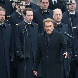 Johnny Hallyday, accompagné par Yodelice et Yarol Poupaud, chante "Un dimanche de janvier" en hommage aux victimes des attentats de janvier et novembre. Place de la République à Paris, le 10 janvier 2016.